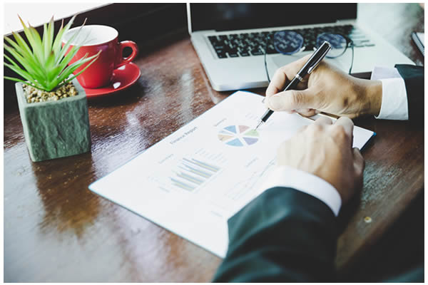 Photo of a business man looking at marketing material that has pie chart graphs on it.