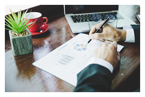 Photo of a business man looking at marketing material that has pie chart graphs on it.